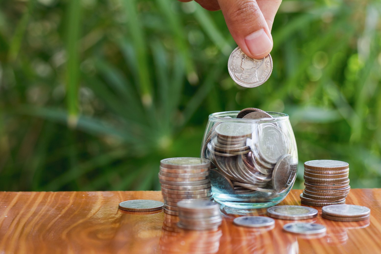 Woman hand putting coinIn the glass jar. Saving money wealth and financial concept, Personal finance, finance management, savings, thrifty or avarice concept